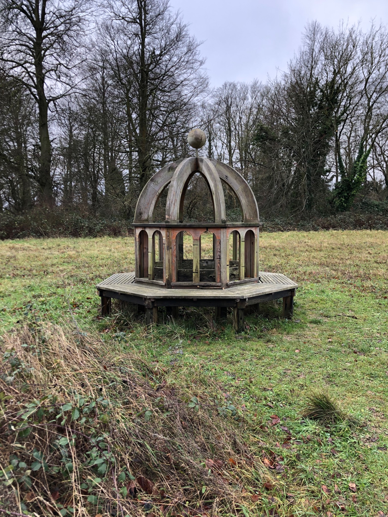 Circular sculptural timber seat among trees