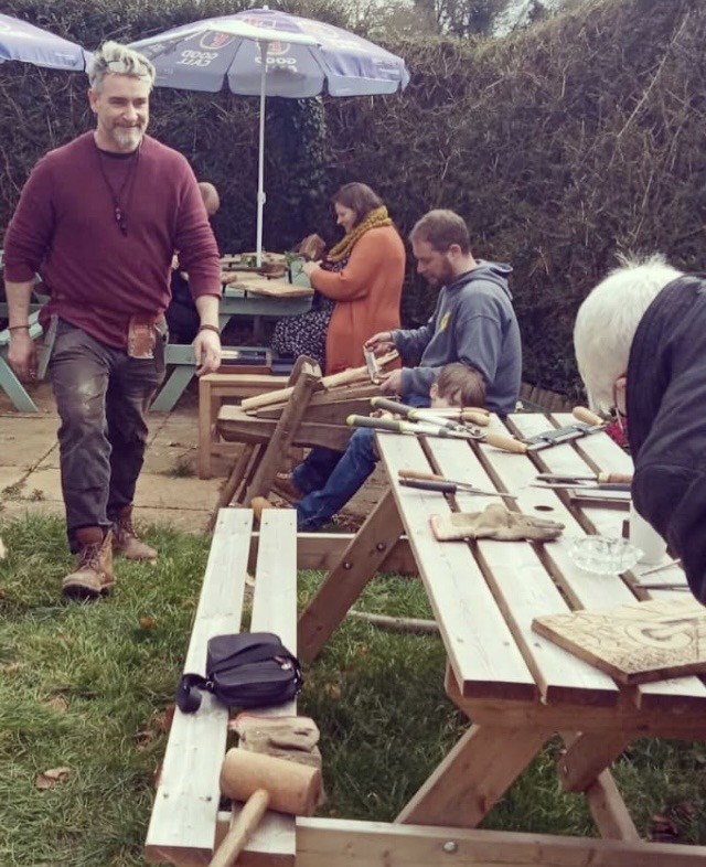 Participants making with wood together outdoors
